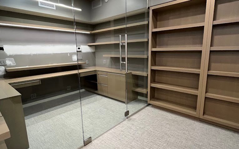 Cleaned office suite with glass partition, shelving and carpet