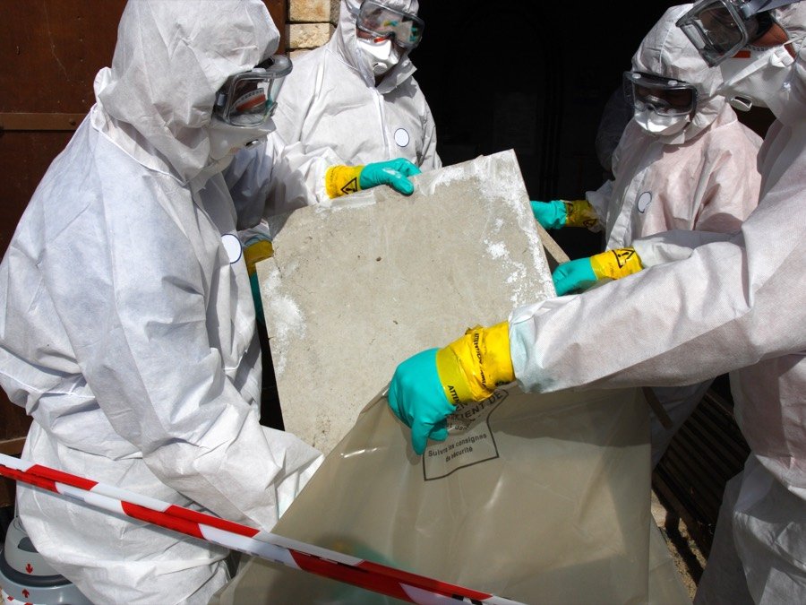 Asbestos containing material being removed under controlled conditions