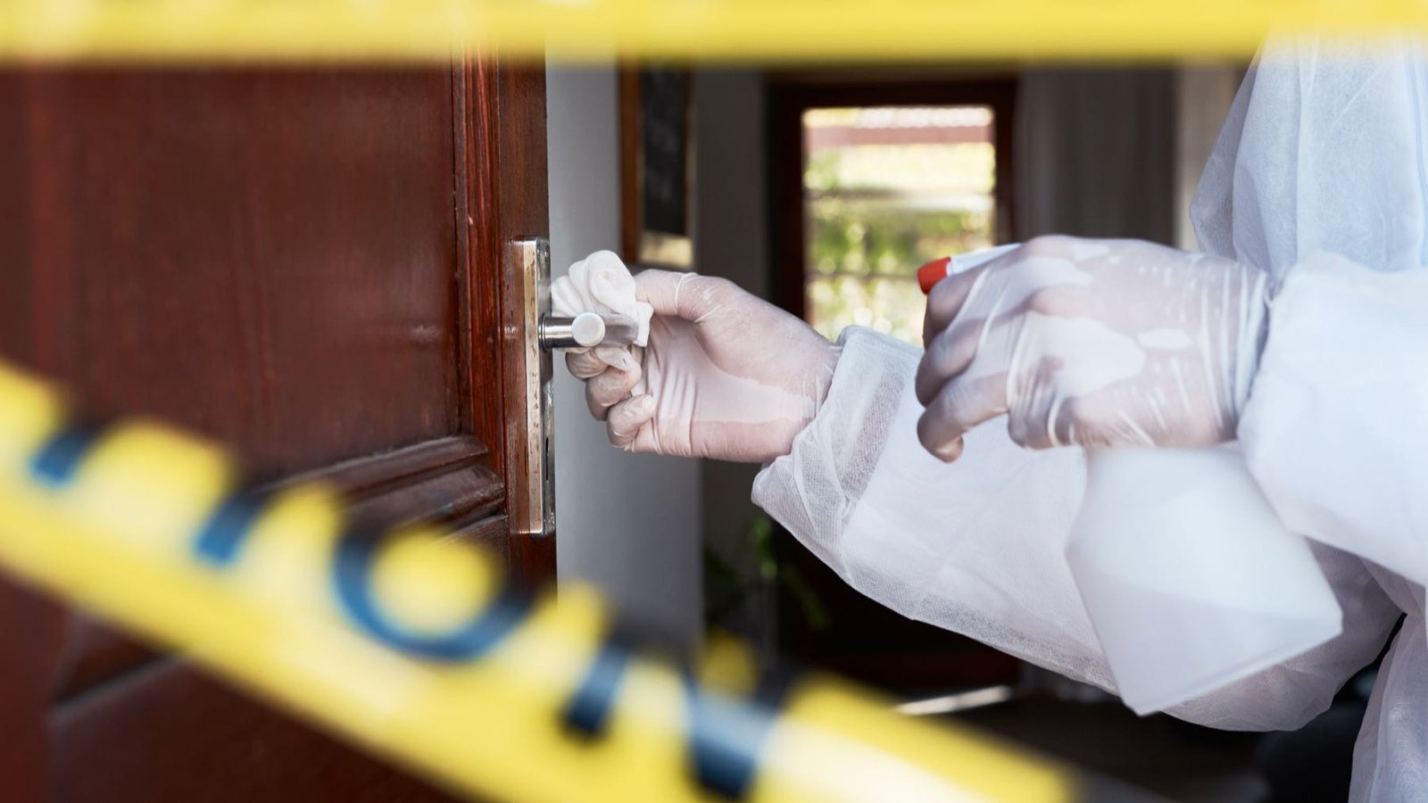Biohazard remediation technician in protective equipment working inside a contained space
