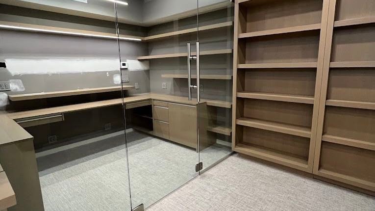 Cleaned office suite with glass partition, shelving and carpet