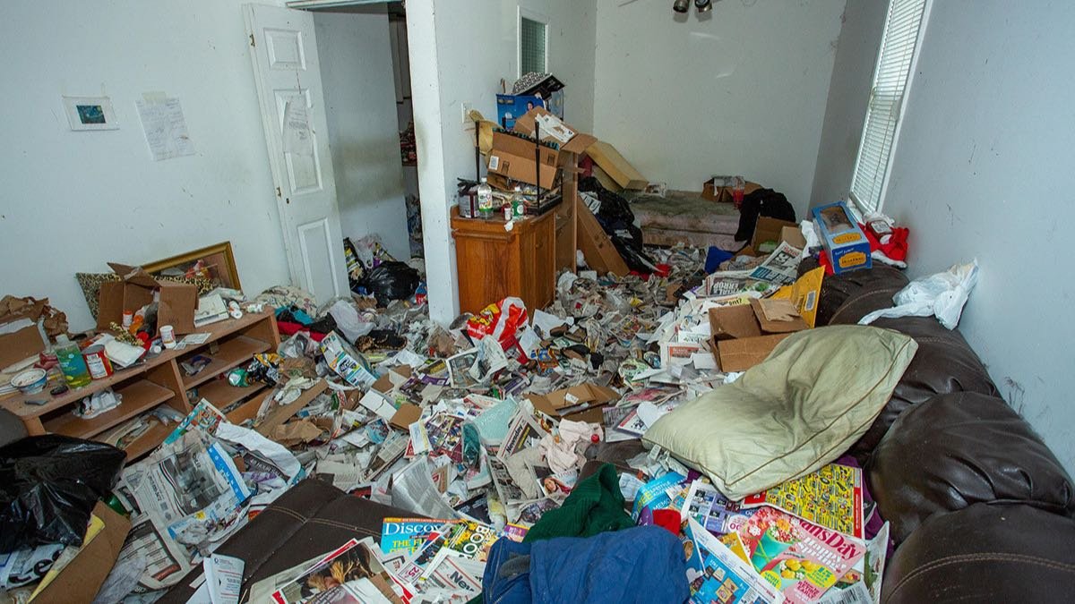 Cluttered room being sorted and cleared during a hoarding cleanup