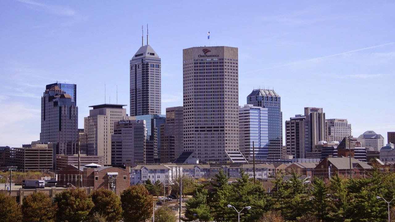 The downtown Indianapolis skyline seen across trees on an autumn afternoon
