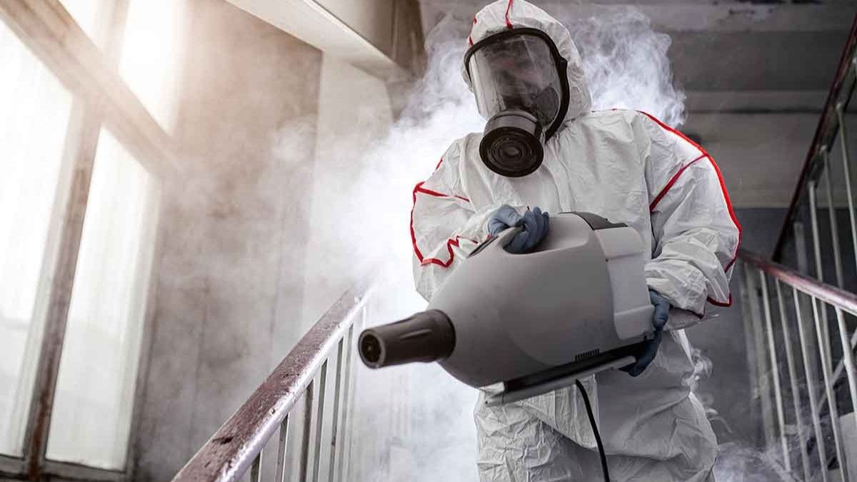 Technician applying disinfectant during an infectious disease decontamination