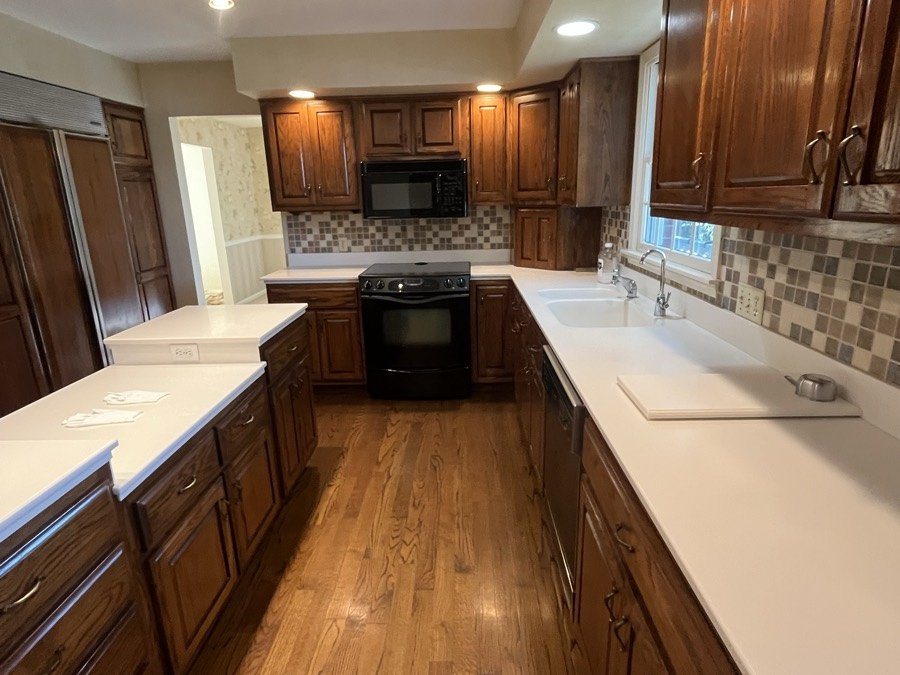 Kitchen with oak cabinets and cleared countertops after a clean