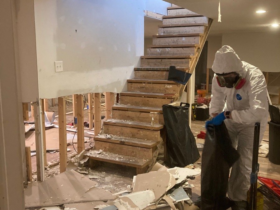 ConvenientConnections technician bagging contaminated debris during a basement remediation